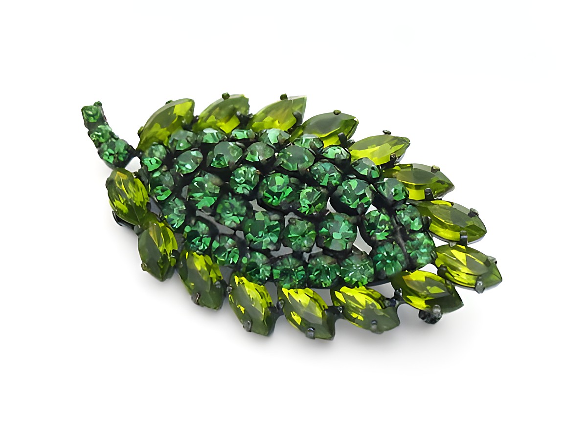 Brosche Sexy City Look Einzelstück Grün von Juwelier Harnisch mit funkelnden Strasssteinen in verschiedenen Grüntönen, die in Form eines Blattes angeordnet sind, ideal für stilvolle Akzente.