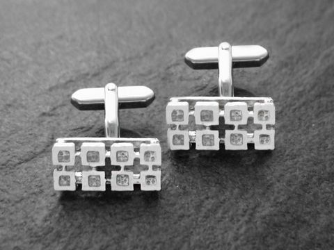 Silberfarbene Manschettenknöpfe im Retro-Stil, rhodiniert, mit einem modernen geometrischen Design. Hersteller ist der Juwelier Harnisch, ideal für stilvolle Anlässe.