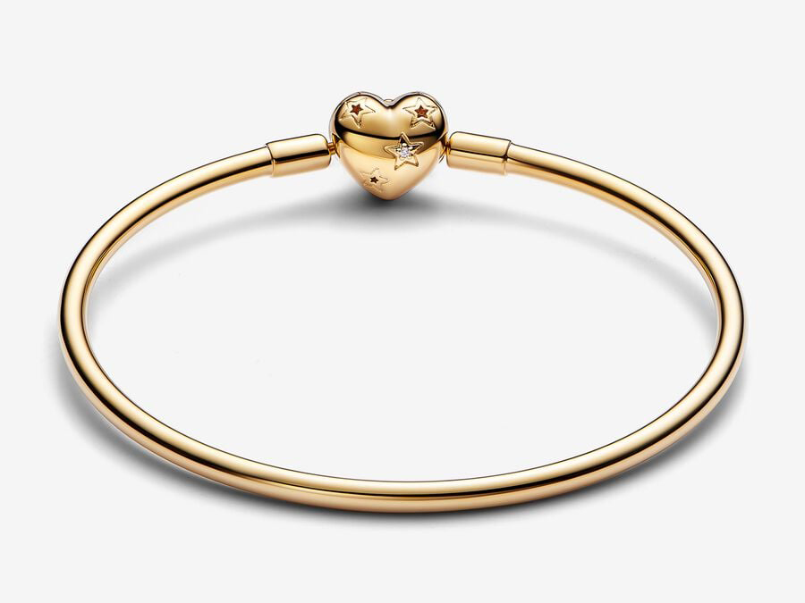 Pandora Armreifen aus gelbgoldvergoldetem Material mit Herzverschluss im Nachthimmel-Design und Zirkonia-Besatz, Länge 17 cm, elegant und modern.