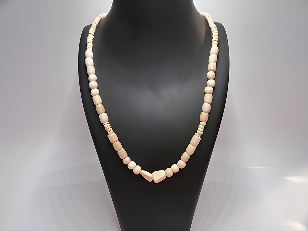Holzkette Multiform 120 mm naturbraun 60 cm aus Holzschmuck von Juwelier Harnisch, zeigt eine harmonische Kombination unterschiedlicher Holzperlen in sanften Farbtönen auf einem Schmuckständer.