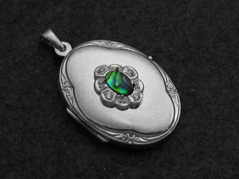 Paua Shell Medaillon aus Sterling Silber mit Brillanten, ovales Design, zentrale eingebettete Paua Muschel, kunstvoll verziert, Hersteller Juwelier Harnisch, luxuriöses Schmuckstück.