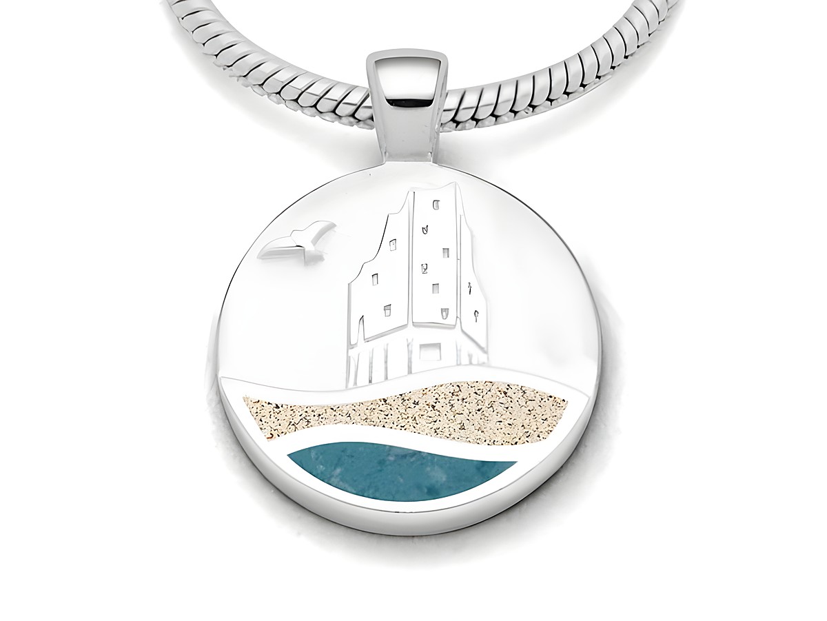 DUR Anhänger mit einem Design von Strandwellen Hamburg, aus rhodiniertem Sterling Silber. Verziert mit Strandsand und blauen Steinsand, zeigt eine stilisierte Strandansicht mit einem Turm und einer Möwe.