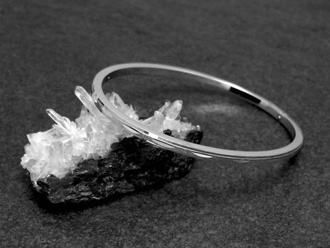 Silber Armreifen feminin echt Silber rhodiniert 18 cm von Juwelier Harnisch, elegant und zeitlos, auf einem schwarzen Hintergrund präsentiert mit natürlichen Mineralien.