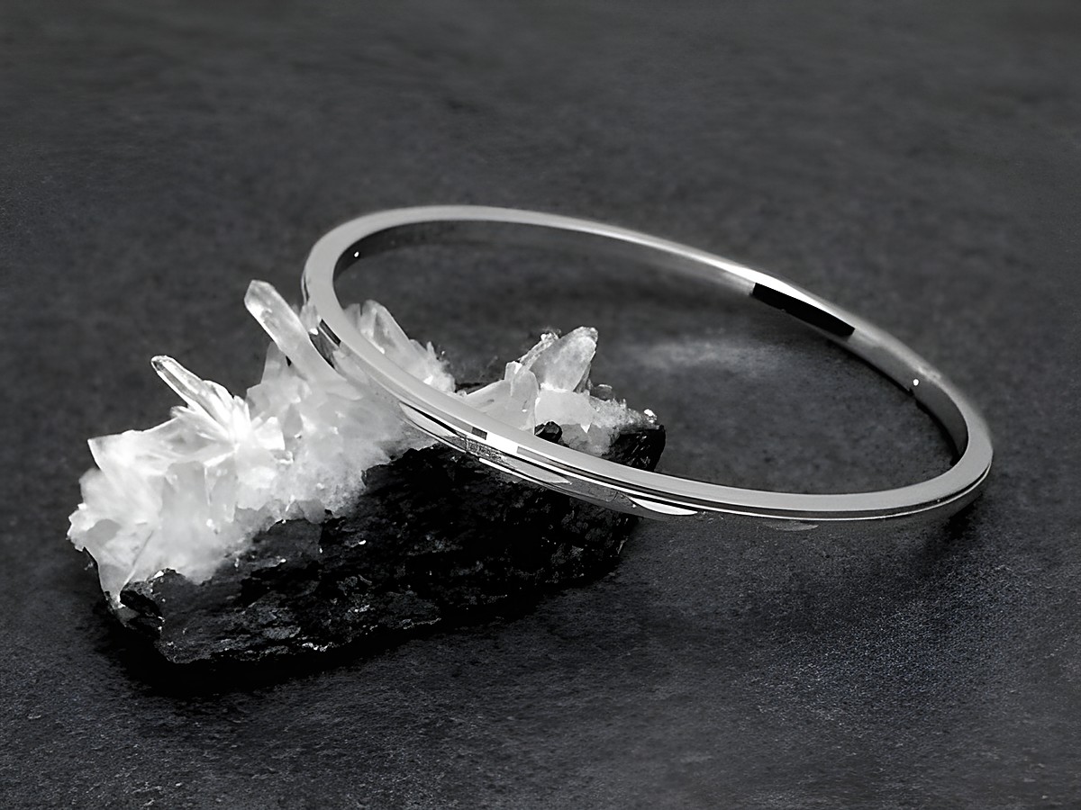 Silber Armreifen feminin echt Silber rhodiniert 18 cm von Juwelier Harnisch, elegant und zeitlos, auf einem schwarzen Hintergrund präsentiert mit natürlichen Mineralien.