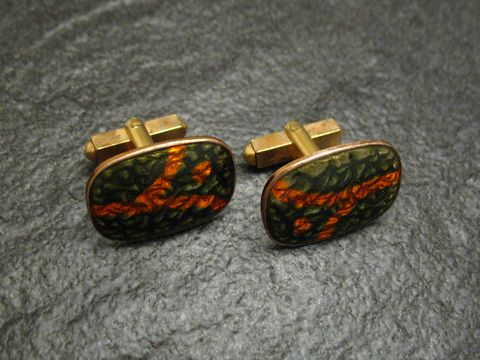 Manschettenknöpfe mit olivoranger Emaille, vergoldet, von Juwelier Harnisch, mit einem einzigartigen, abstrakten Design, ideal für stilvolle Anlässe.