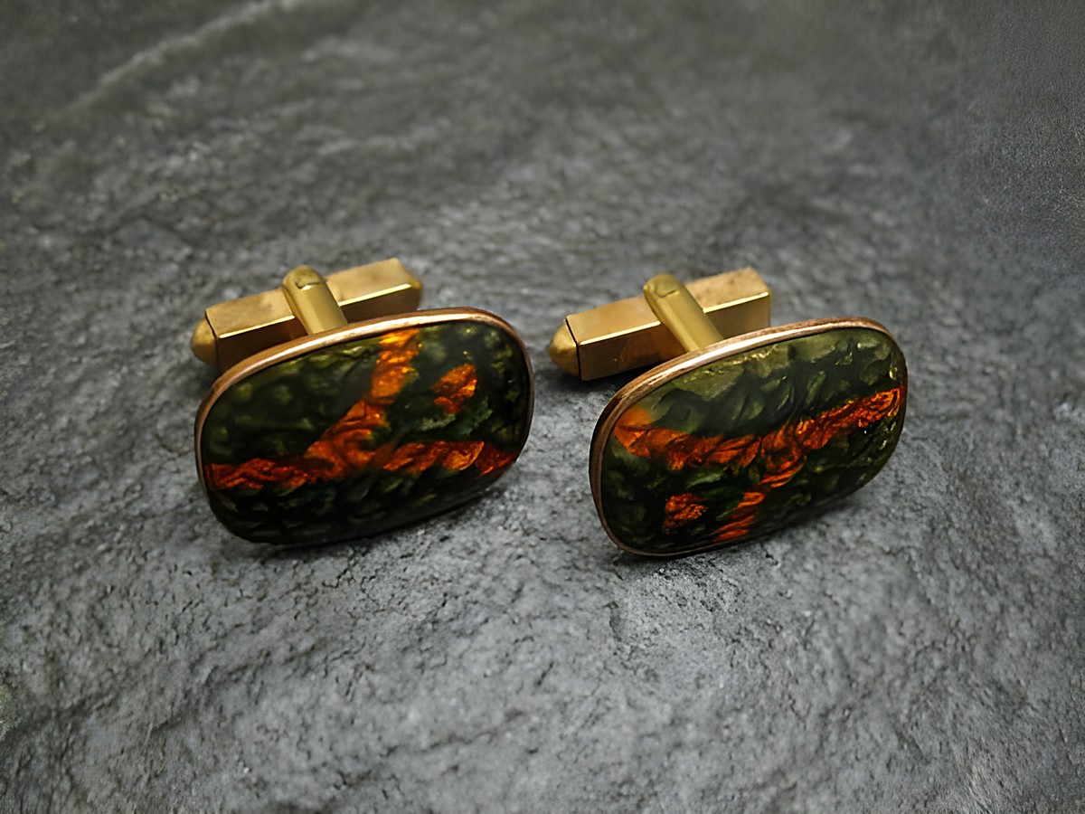 Manschettenknöpfe mit olivoranger Emaille, vergoldet, von Juwelier Harnisch, mit einem einzigartigen, abstrakten Design, ideal für stilvolle Anlässe.