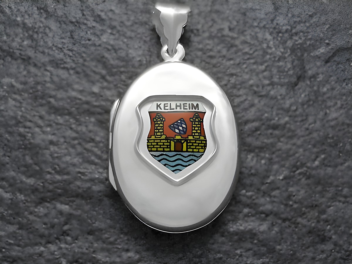 Das Bild zeigt ein silbernes Medaillon mit dem Stadtwappen von Kelheim, Deutschland. Das Wappen ist farbenfroh und zeigt eine Burg sowie Wellen, eingearbeitet in das Medaillon des Juweliers Harnisch aus Bayern.