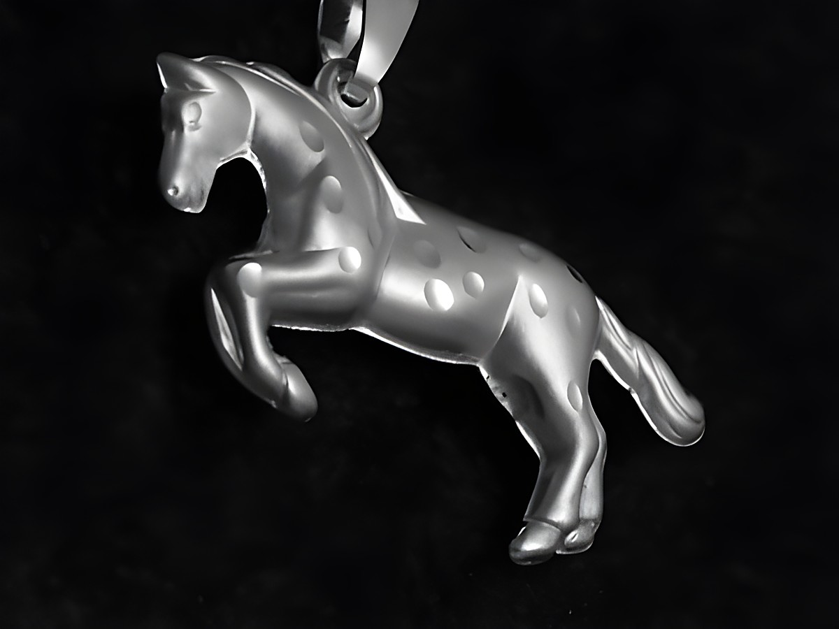 Ein filigraner Anhänger aus Sterling Silber in Form eines Pferdes. Das Pferd ist elegant in einer aktiven Pose dargestellt und weist eine glatte Oberfläche auf. Ideal für Tierliebhaber.