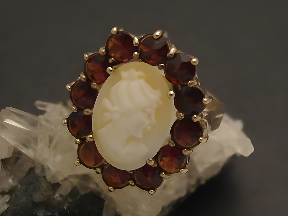 Goldring Gemme elegant aus Gold 333 mit Granatsteinen, Größe 55 bis 56/18, mit einer kunstvoll gestalteten Statuette. Hersteller: Juwelier Harnisch.