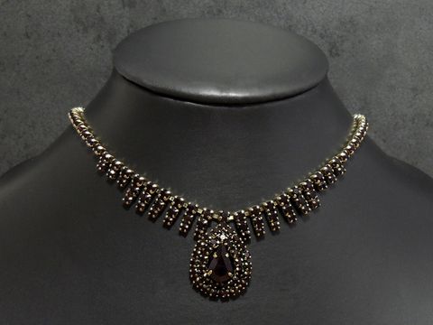Strass Kette in excellence GRANATROT 46-49 cm, goldfarben, Hersteller Juwelier Harnisch, Fassung goldfarben mit dekorativen Elementen und einem tropfenförmigen Anhänger.