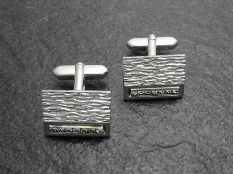 Manschettenknöpfe in silber-farben mit strukturiertem Design und einem weißen Strass Stein. Hersteller: Juwelier Harnisch, ideal für elegante Anlässe.