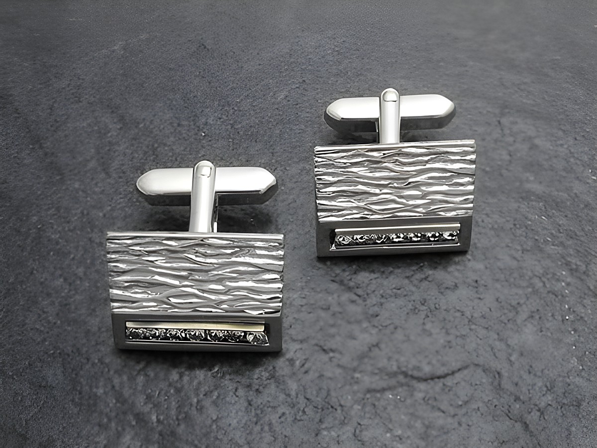 Manschettenknöpfe in silber-farben mit strukturiertem Design und einem weißen Strass Stein. Hersteller: Juwelier Harnisch, ideal für elegante Anlässe.