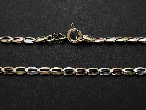 Haferkorn Kette aus Gold 333 in tricolor, 40 cm lang, gefertigt vom Juwelier Harnisch, auf schwarzem Hintergrund, elegante Verbindung von Farbtönen.