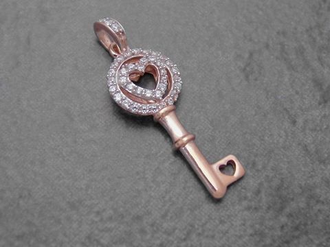 Ein eleganter Schlüsselanhänger aus rhodiniertem Sterling Silber in Rosé mit funkelnden Zirkonia-Steinen und einem herzförmigen Design, hergestellt von Juwelier Harnisch.