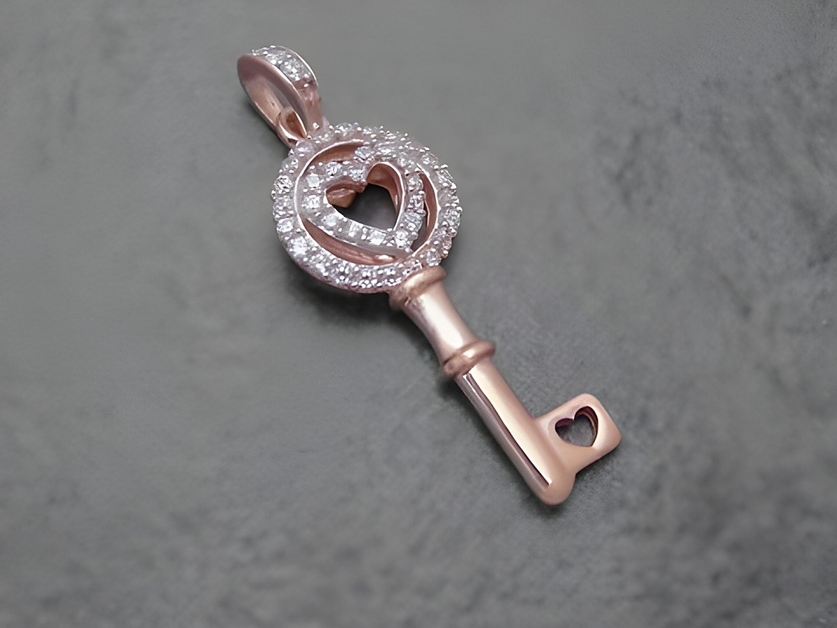 Ein eleganter Schlüsselanhänger aus rhodiniertem Sterling Silber in Rosé mit funkelnden Zirkonia-Steinen und einem herzförmigen Design, hergestellt von Juwelier Harnisch.