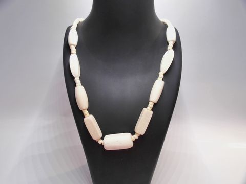 Holzkette Multiform 33 mm naturbraun 60 cm Holz Schmuck von Juwelier Harnisch, elegant und zeitlos, bestehend aus verschieden geformten Holzstücken, auf einem Schmuckdisplay präsentiert.
