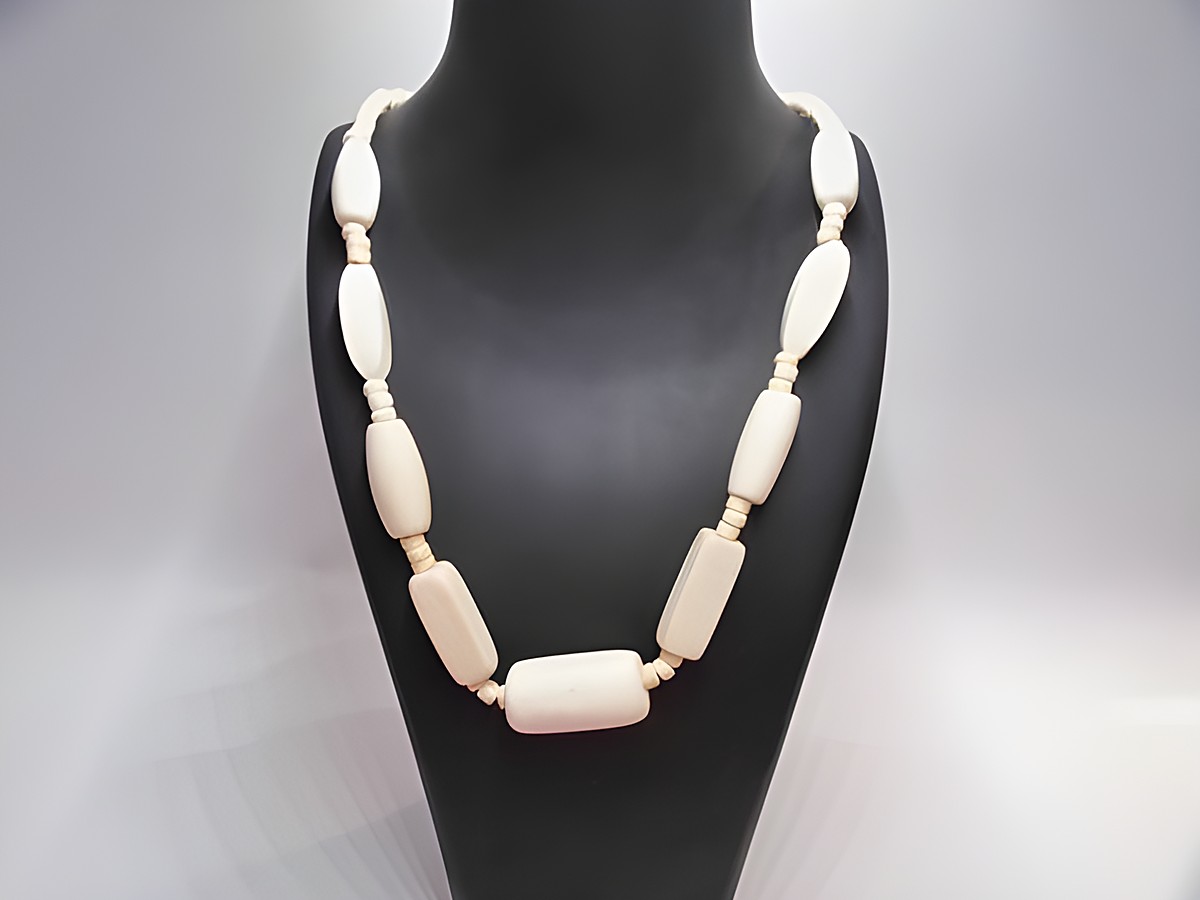 Holzkette Multiform 33 mm naturbraun 60 cm Holz Schmuck von Juwelier Harnisch, elegant und zeitlos, bestehend aus verschieden geformten Holzstücken, auf einem Schmuckdisplay präsentiert.