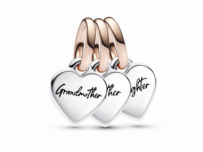 Drei herzförmige Charm-Anhänger aus Sterling Silber mit Roségold Vergoldung. Die Anhänger tragen die Worte Großmutter, Tochter und Enkelin und symbolisieren Familiengenerationen.