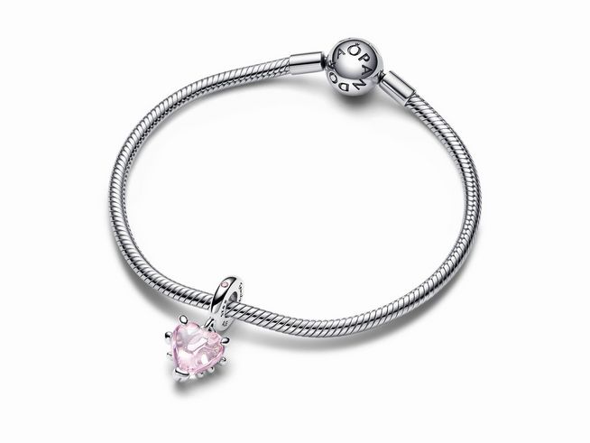 Rosafarbener Stammbaum und Herz Charm-Anhänger aus Sterling Silber von Pandora, der Anhänger hat eine herzförmige rosa Steinfassung und hängt an einem eleganten Silberarmband.