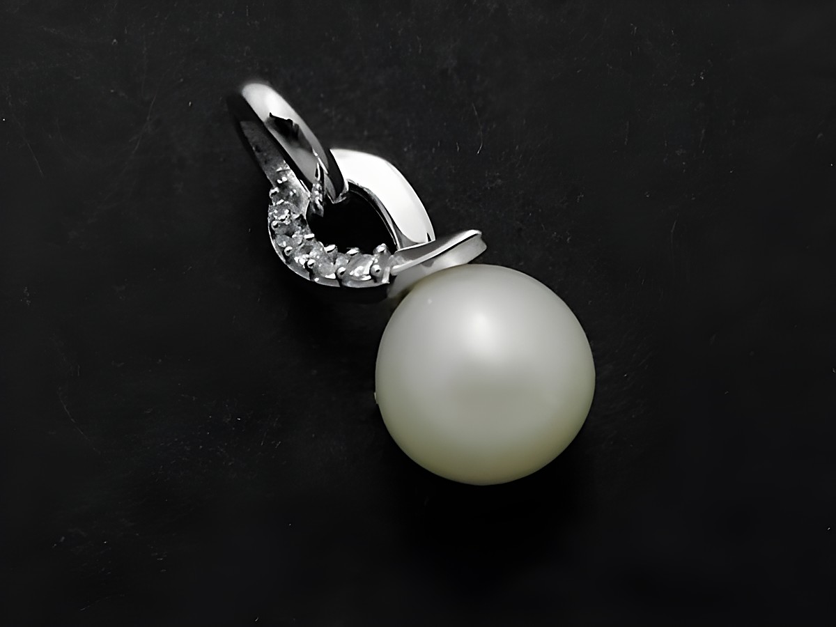 Silber Anhänger mit verschlungener Form, verziert mit einer Süßwasserzuchtperle und Zirkonia, filigran und elegant, Hersteller Juwelier Harnisch, ideal für jeden Anlass.
