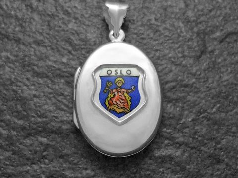 Silbernes Medaillon mit dem Wappen von Oslo, Norwegen. Das Wappen zeigt den Schriftzug Oslo und eine historische Figur auf blauem Hintergrund. Hergestellt von Juwelier Harnisch.