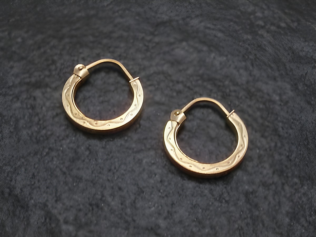 Creole aus Gold mit einem Durchmesser von 1,5 cm und einer Stärke von 1,8 mm, verziert mit einem süßen Muster, hergestellt von Juwelier Harnisch, für Ohrschmuck bis 15 mm geeignet.