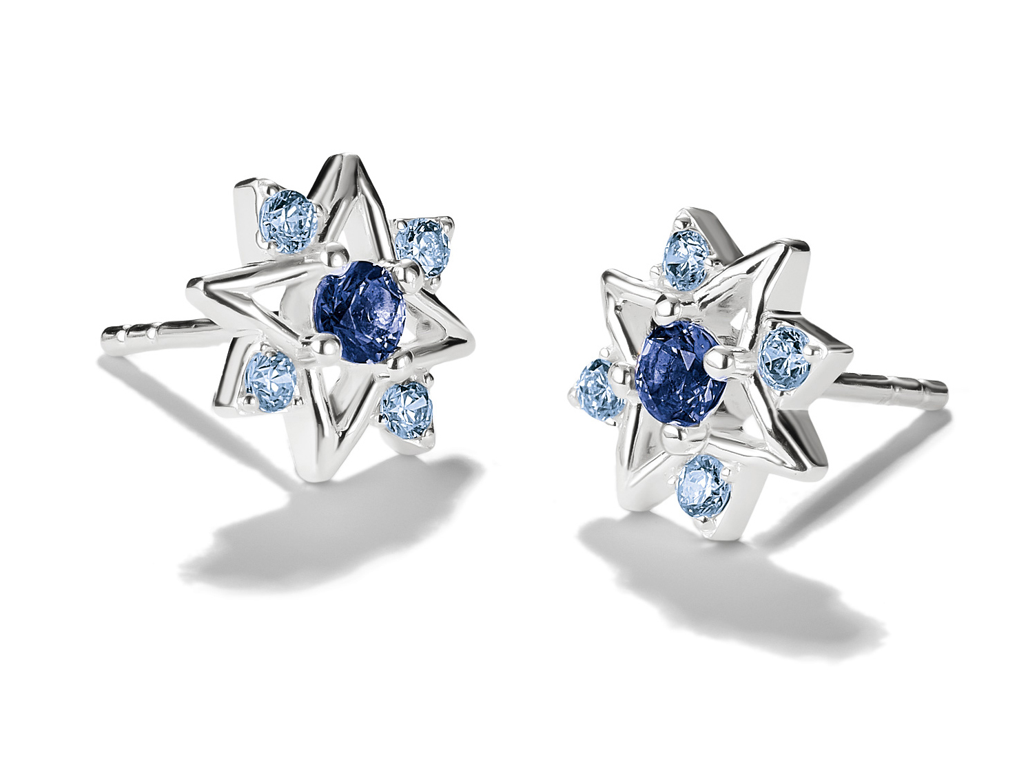 Zwei Ohrstecker in Sternform aus 925 Sterling Silber mit Zirkonia und einem Nanokristall in Blau, entworfen von Thomas Sabo als Neuheit.