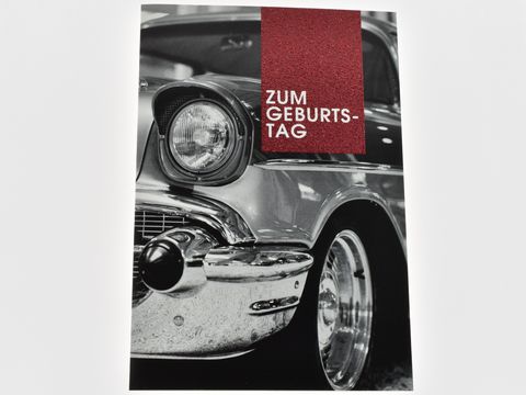 Geburtstagskarte mit einem klassischen Auto, das eine glänzende Chromstoßstange zeigt, verziert mit dem Schriftzug "Zum Geburtstag". Hersteller: Juwelier Harnisch.