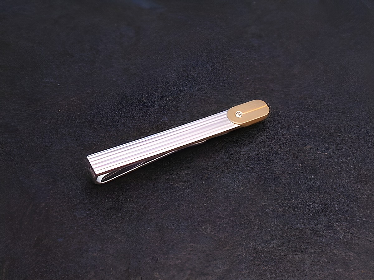 Krawattenklammer aus echtem Silber mit Zirkonia, Hersteller Juwelier Harnisch. Moderne, elegante Gestaltung mit goldfarbener Akzentierung und feiner Rillenstruktur für stilvolle Anlässe.