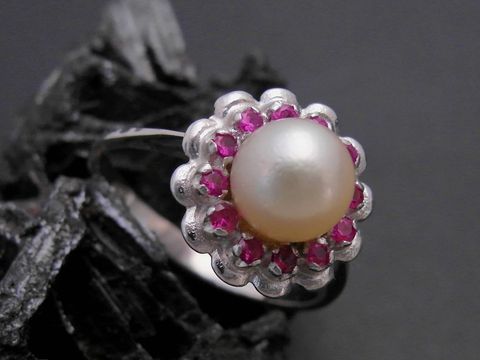 Weißgold Perlen Ring mit blühender Optik, Größe 57, 6,9 mm Zuchtperle in der Mitte, umgeben von synthetischen Rubinen, Hersteller Juwelier Harnisch, bis Größe 58 erhältlich.