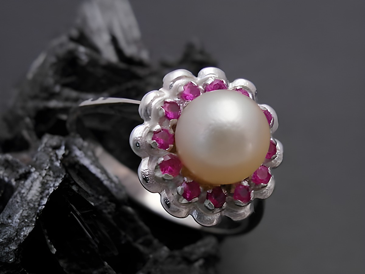 Weißgold Perlen Ring mit blühender Optik, Größe 57, 6,9 mm Zuchtperle in der Mitte, umgeben von synthetischen Rubinen, Hersteller Juwelier Harnisch, bis Größe 58 erhältlich.