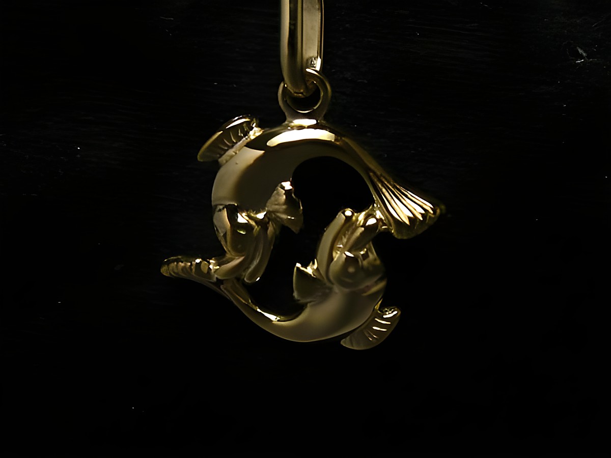 Polierter Goldanhänger im Design des Sternzeichens Fische, dargestellt durch zwei stilisierte Fische, die sich umkreisen. Hersteller: Juwelier Harnisch.