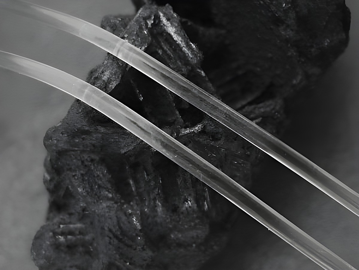 Transparente 45 cm Silikonbänder mit 3 mm Durchmesser und Silber Karabiner, Hersteller Juwelier Harnisch, auf einer dunklen Oberfläche platziert.
