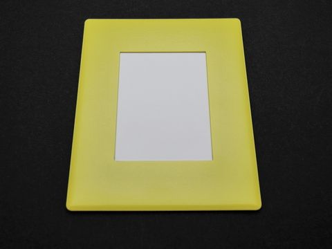 Ein gelber Bilderrahmen aus Kunststoff mit den Maßen 7 x 5,5 cm, geeignet für Bilder in der Größe 4 x 3 cm, ermöglicht individuelle Gravuren und ist ideal zur Präsentation von Fotos.