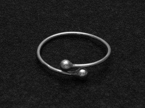 Silberring mit zwei kleinen Kugeln in der Mitte, weit verstellbar, Hersteller: Juwelier Harnisch, ohne Stein.