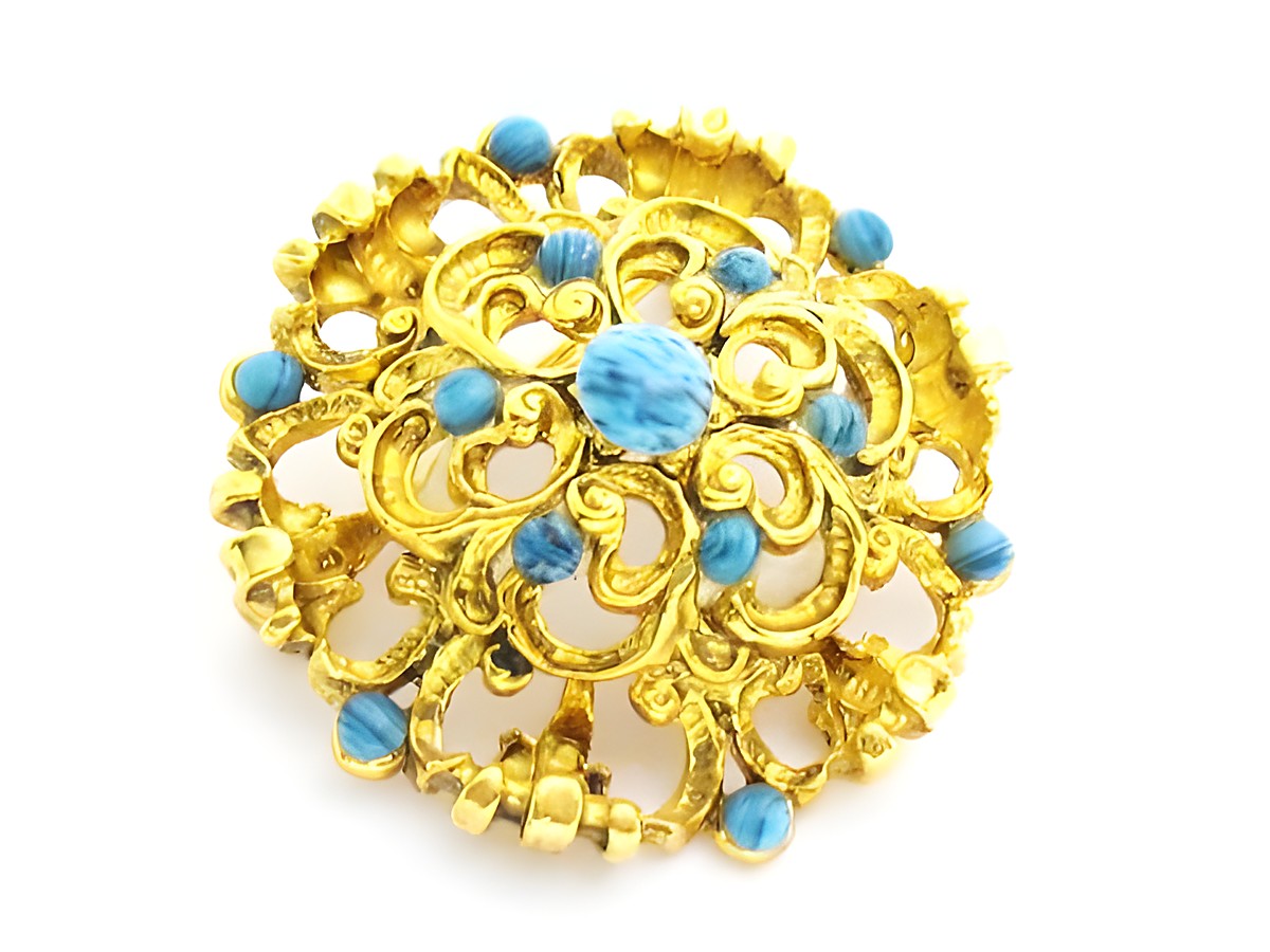 Damen Brosche im Sexy City Look in Blau rund, Hersteller Juwelier Harnisch, mit türkisen Akzenten und filigranem goldfarbenem Design, idealer Schmuck für jeden Anlass.