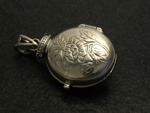 Medaillon aus Sterling Silber mit nostalgischen floralen Motiven, Hersteller Juwelier Harnisch, mit Rubinstein, elegant und zeitlos gestaltet. Ideal als Schmuckstück oder Sammlerstück.