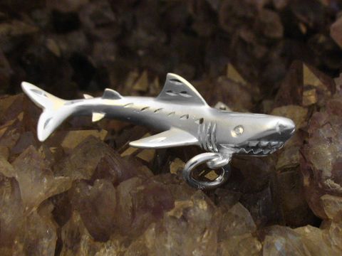 Ein glänzender Anhänger in Form eines Hais aus Sterling Silber mit detaillierter Gestaltung und einem edlen Diamantschliff, ideal für Tierliebhaber und Schmuckliebhaber.
