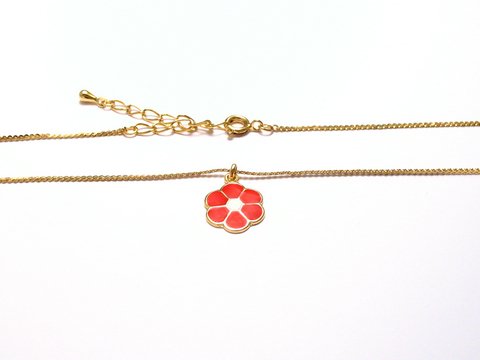 Kinderschmuck mit einem roten Blumenanhänger und einer goldenen Kette, hergestellt von Juwelier Harnisch. Elegant und verspielt für junge Schmuckliebhaber.