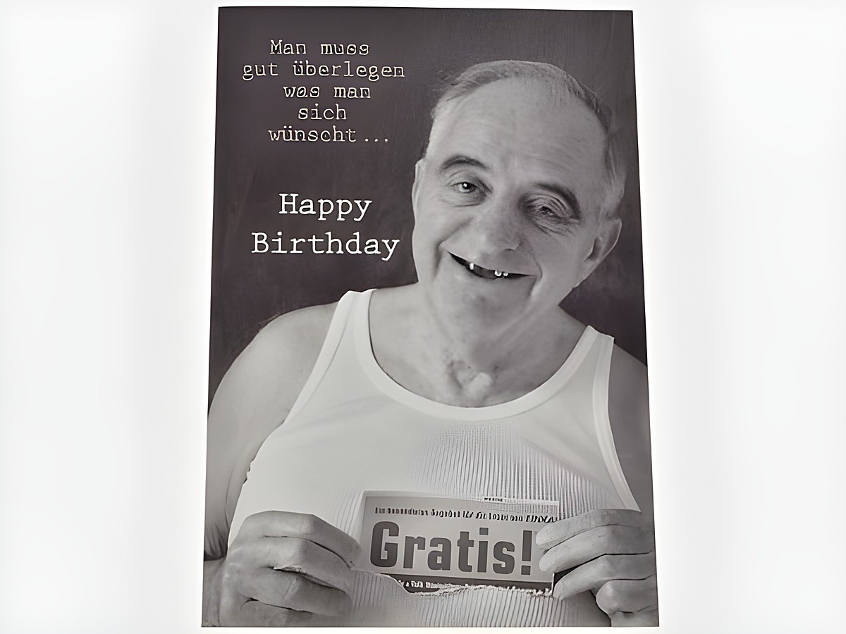Eine humorvolle Geburtstagskarte zeigt einen älteren Herrn in einem weißen T-Shirt. Er lächelt und hält ein Schild mit der Aufschrift Gratis. Text oben enthält einen witzigen Spruch zum Geburtstag.
