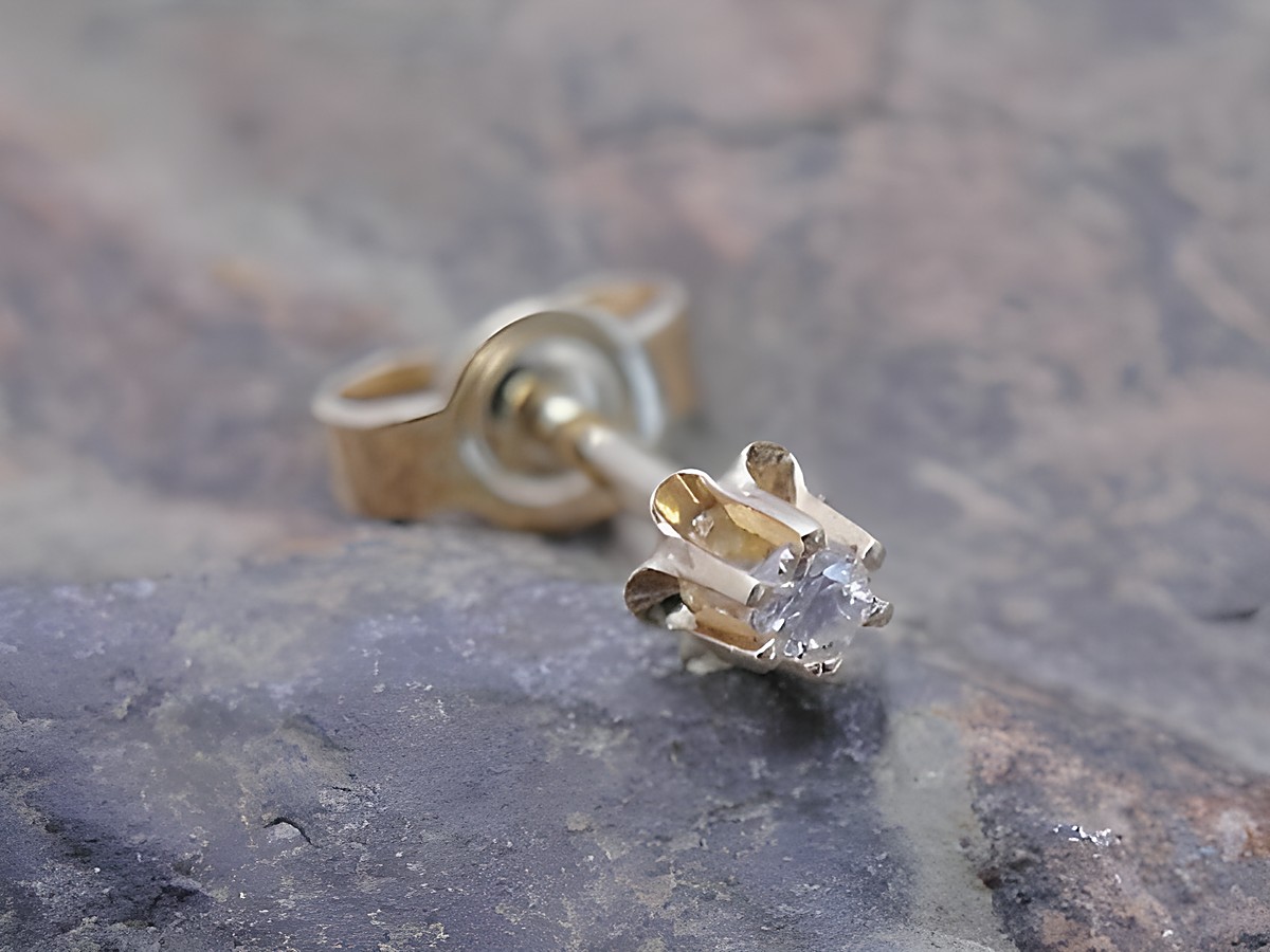 Rund 1 Ohrstecker unisex Gold 333 filigran mit Brillant, Hersteller Juwelier Harnisch, Einzelohrringe 1 Stück, auf grauem Hintergrund, elegant und zeitlos.