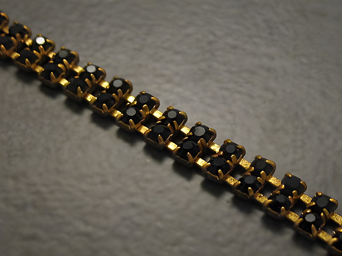 Strass Armband in schwarz mit goldfarbenen Elementen, zart und elegant, Hersteller Juwelier Harnisch, ideale Ergänzung für stilvolle Outfits, Länge 18,5 cm.