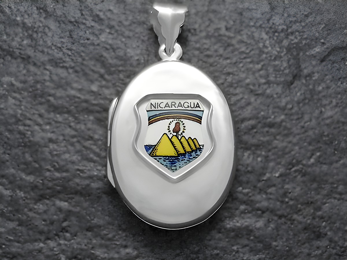 Silbernes Medaillon mit dem Wappen von Nicaragua, das die charakteristischen gelben Vulkane und das Blau des Wassers zeigt, umgeben von einem ovalen Rahmen. Hochschaliger Anhänger aus hochwertigem Material.