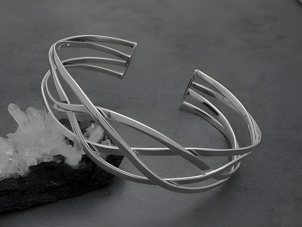 Silber Armreifen geflochten aus Sterling Silber mit einem Durchmesser von 19,5 mm und einer Länge von 19,3 cm, hergestellt von Juwelier Harnisch, elegant und modern, auf einer dunklen Unterlage.