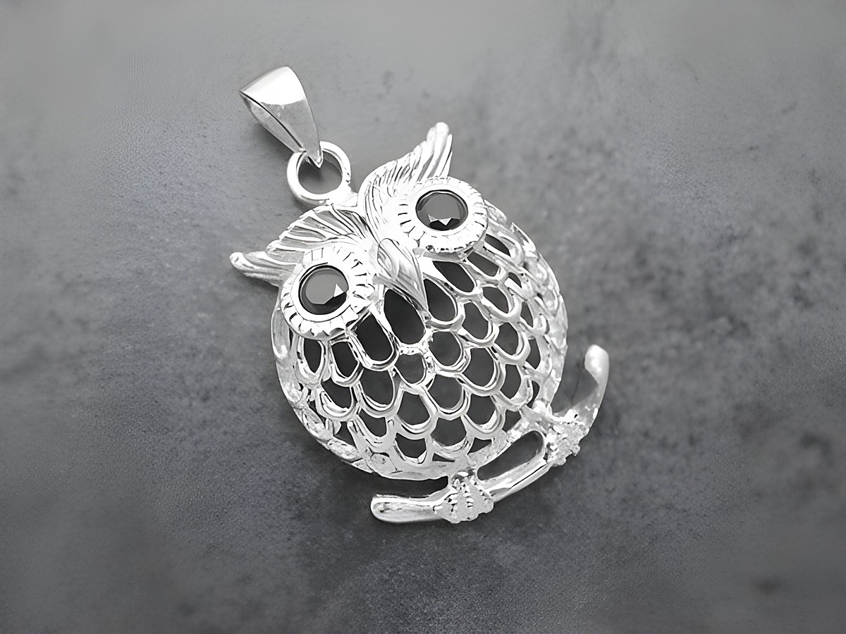 Silber Anhänger einer Eule auf einem Ast, mit Zirkonia in schwarz, symbolisiert einen Glücksbringer, hergestellt von Juwelier Harnisch, ideal für Tierliebhaber.
