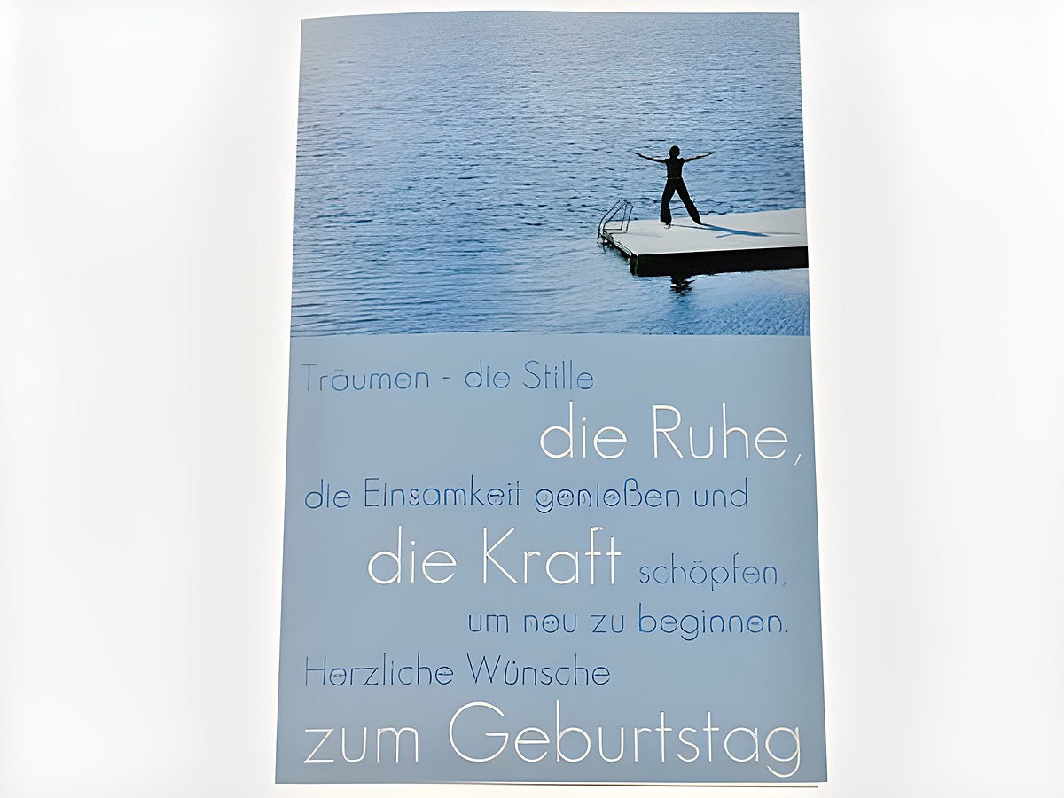 Eine Geburtstagskarte mit dem Motiv eines Stegs am Wasser, auf dem eine Person steht. Der Text auf der Karte spricht von Träumen, Ruhe und Kraft sowie herzlichen Geburtstagswünschen. Hersteller: Juwelier Harnisch.