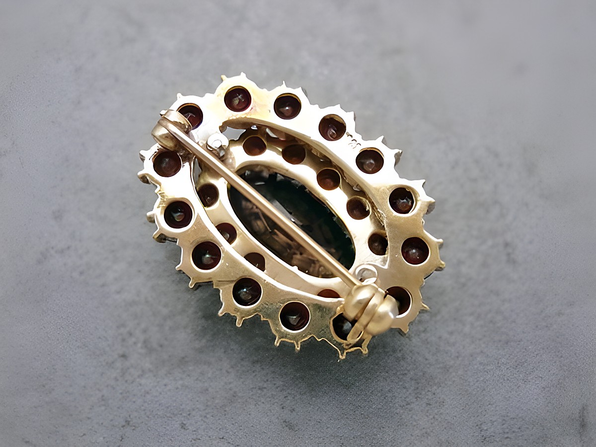 Oval geformte Granat Schmuck Brosche in Gold mit einer Größe von 29,2 mm, hergestellt von Juwelier Harnisch, verziert mit mehreren Granatsteinen. – Ansicht 2