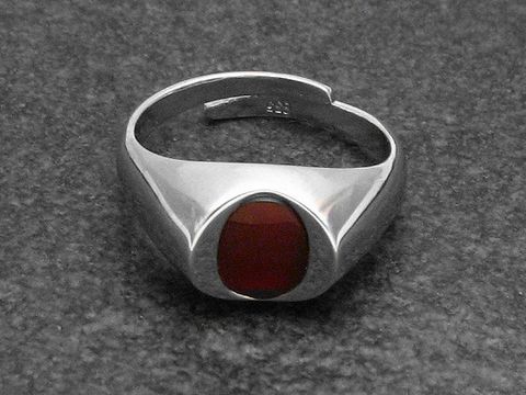 Silberring mit verstellbarer Größe, rhodiniert und mit einem ovalen Karneol versehen. Modernes Design, geeignet für verschiedene Handgrößen, Hersteller Juwelier Harnisch.