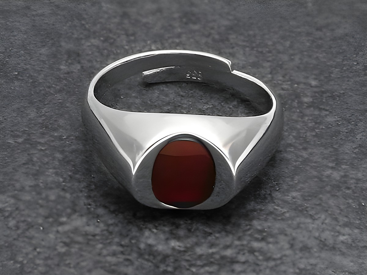 Silberring mit verstellbarer Größe, rhodiniert und mit einem ovalen Karneol versehen. Modernes Design, geeignet für verschiedene Handgrößen, Hersteller Juwelier Harnisch.
