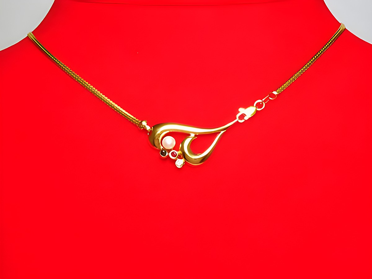 Gold Collier 585 mit einer Zuchtperle, Saphir, Rubin und Zirkonia, 44cm lang, Hersteller Juwelier Harnisch, elegant und zeitlos gestaltet, auf rotem Hintergrund präsentiert.